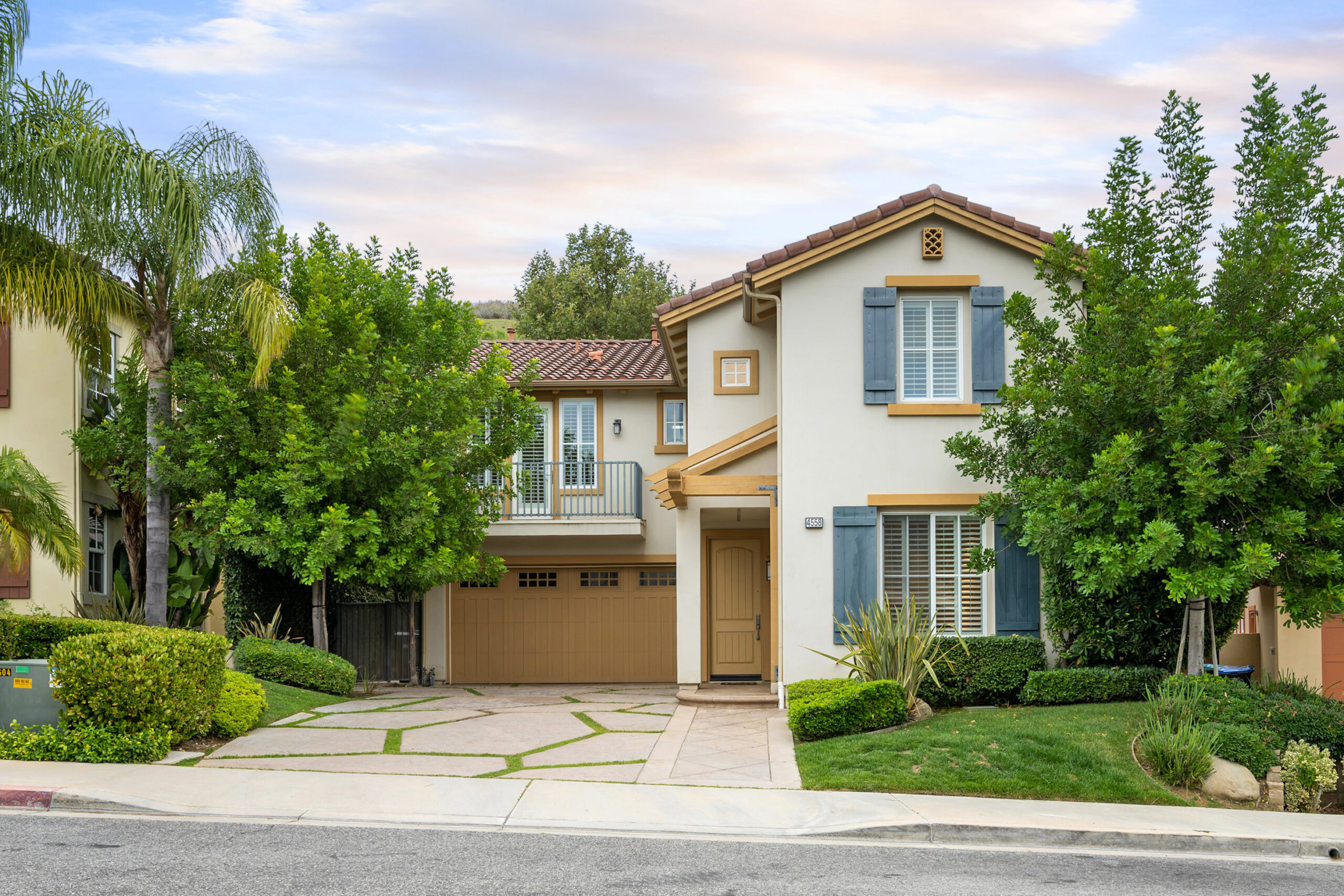 two-story-house-with-a-garage-and-front-yard-trees-2024-06-20-18-20-13-utc